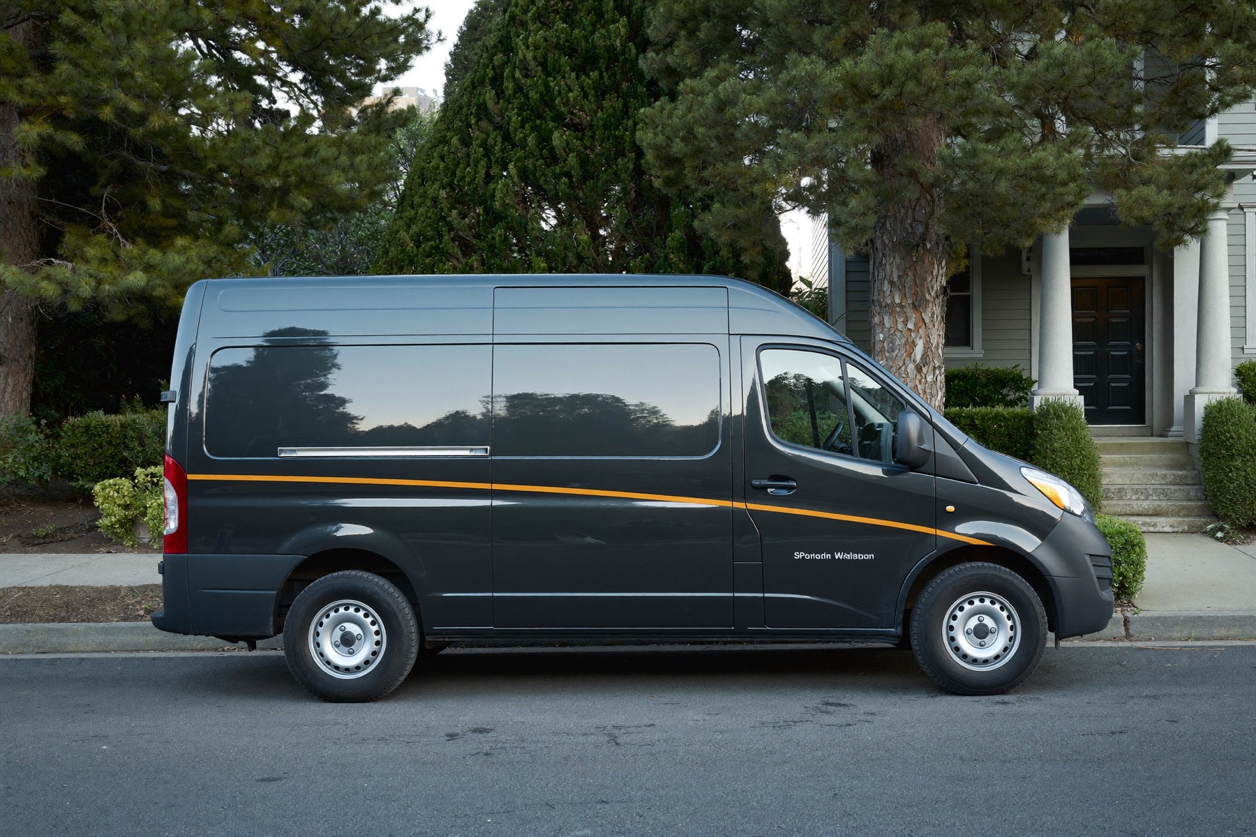 An Alder Electric van on a pine-lined Spokane residential street